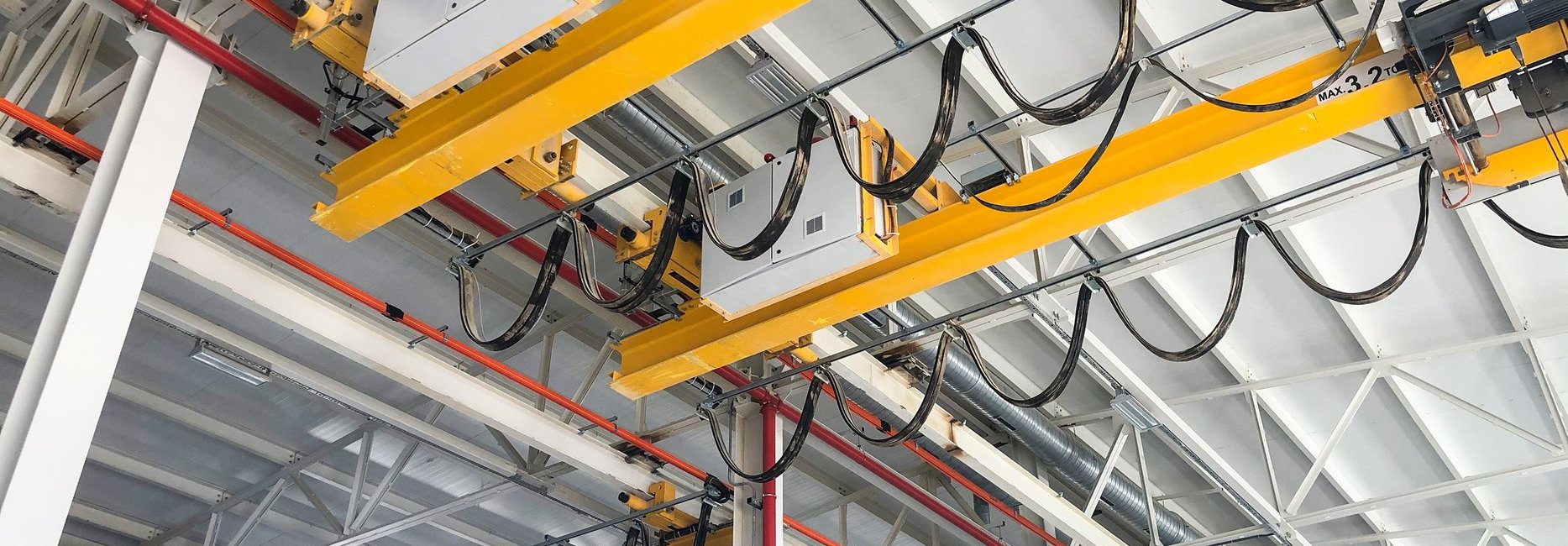 Overhead cranes inside industrial building. Bridge cranes inside hangar.